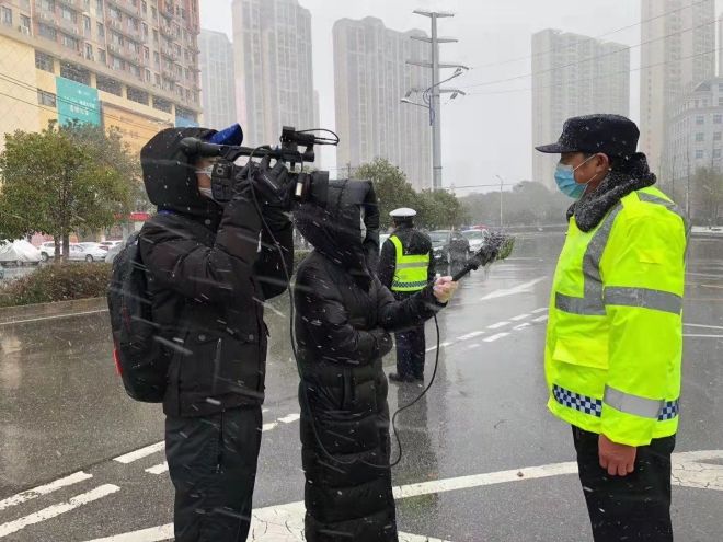 孝感市融媒體中心楊亞玲（風(fēng)雪中，采訪疫情期間重返一線的退休警察）_副本.jpg.jpg