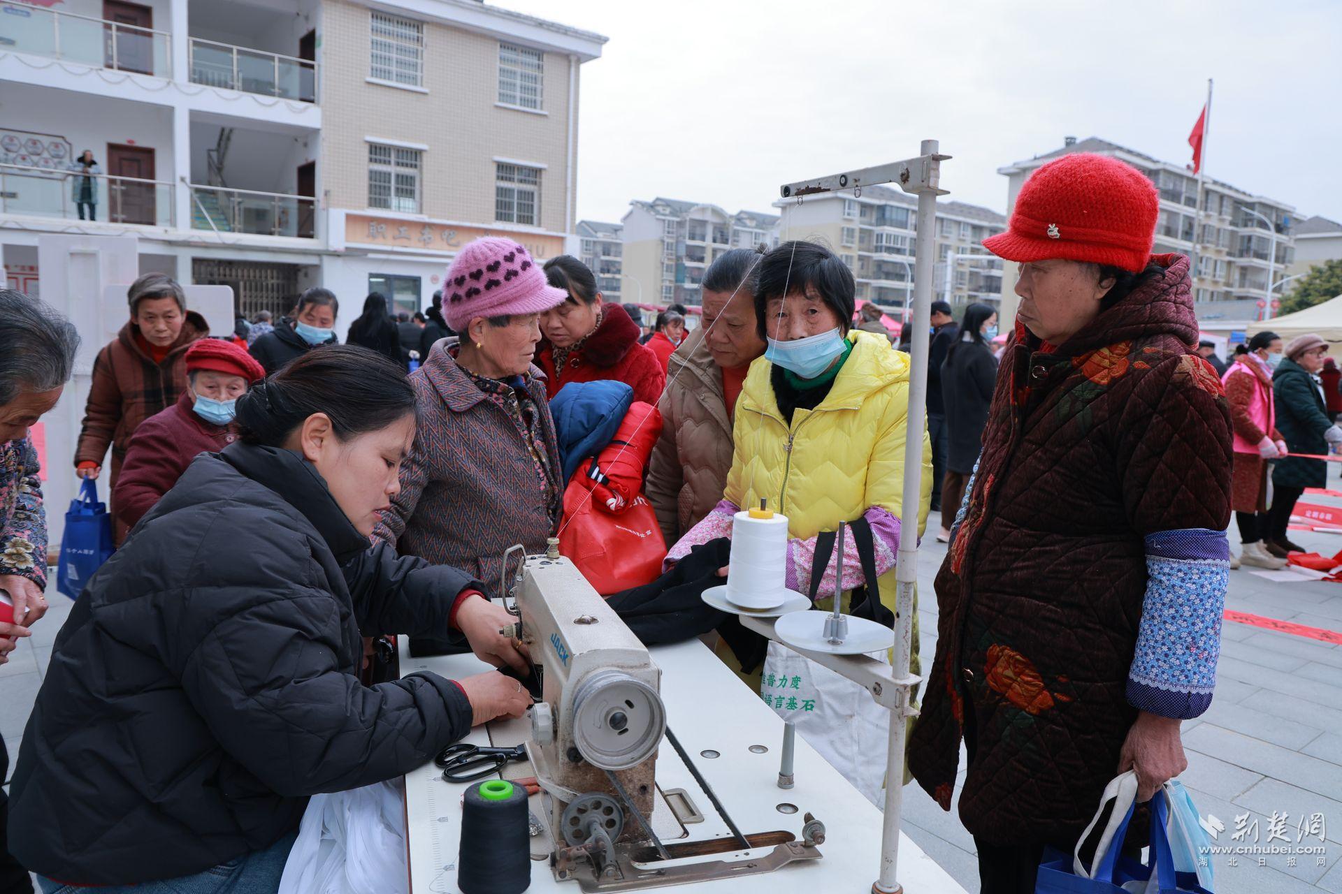 衣物縫補(bǔ)攤前，志愿者飛針走線(xiàn)為居民修補(bǔ)破損衣物.jpg.jpg